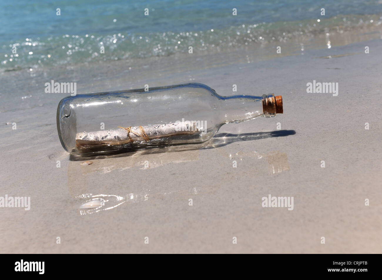 Un messaggio in bottiglia sulla riva sabbiosa Foto Stock