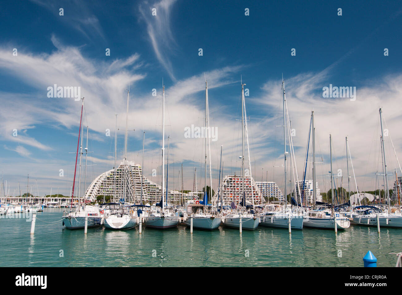 Barche a vela nel porto di yacht e edifici dell'hotel nel resort per vacanze La Grande Motte, France, Languedoc-Roussillon Foto Stock