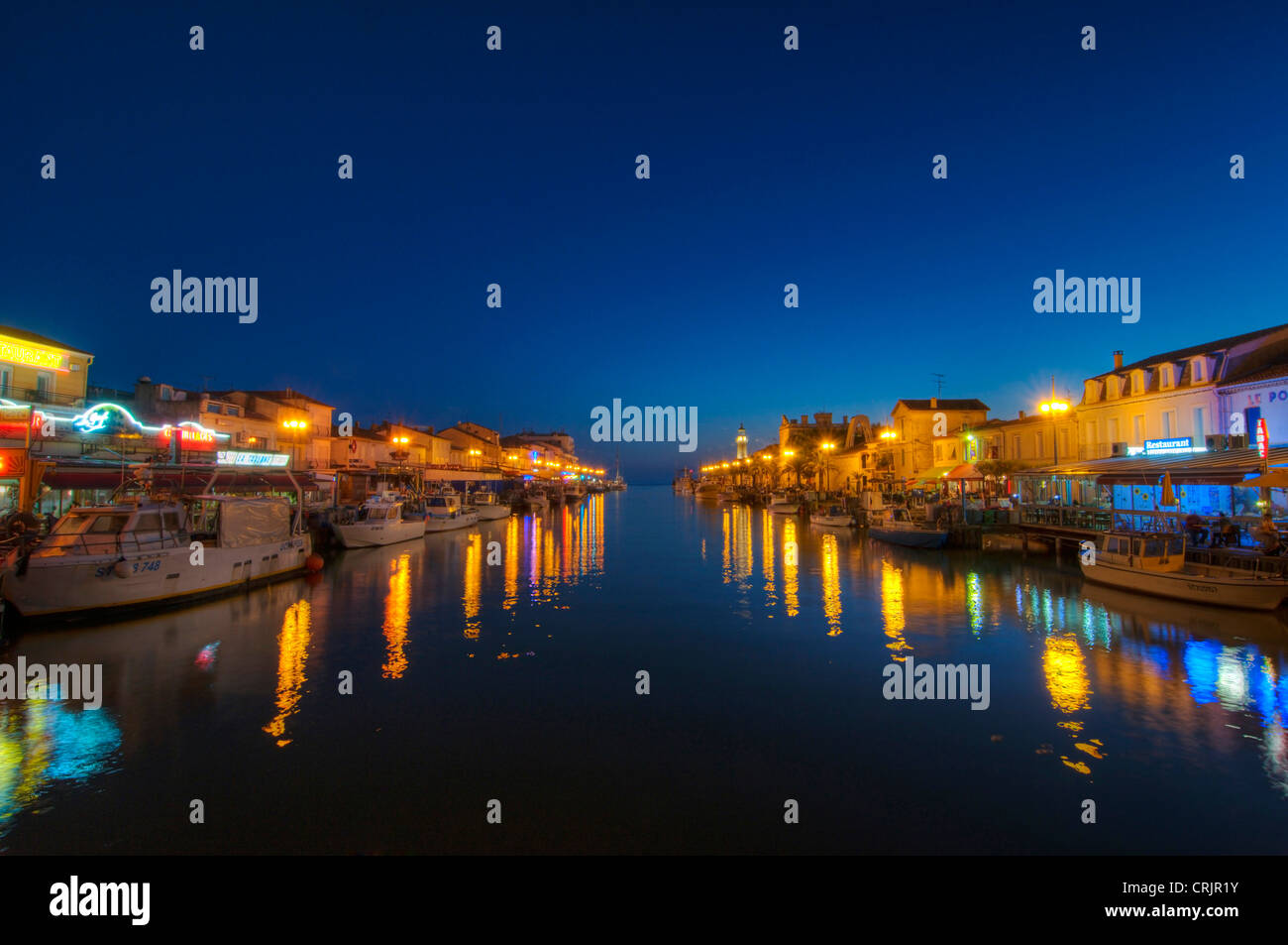 Il chanal in Le Grau-du-Roi al crepuscolo, con barche da pesca e ristoranti su entrambi i lati del chanal, France, Languedoc-Roussillon, Camargue, Le Grau-du-Roi Foto Stock