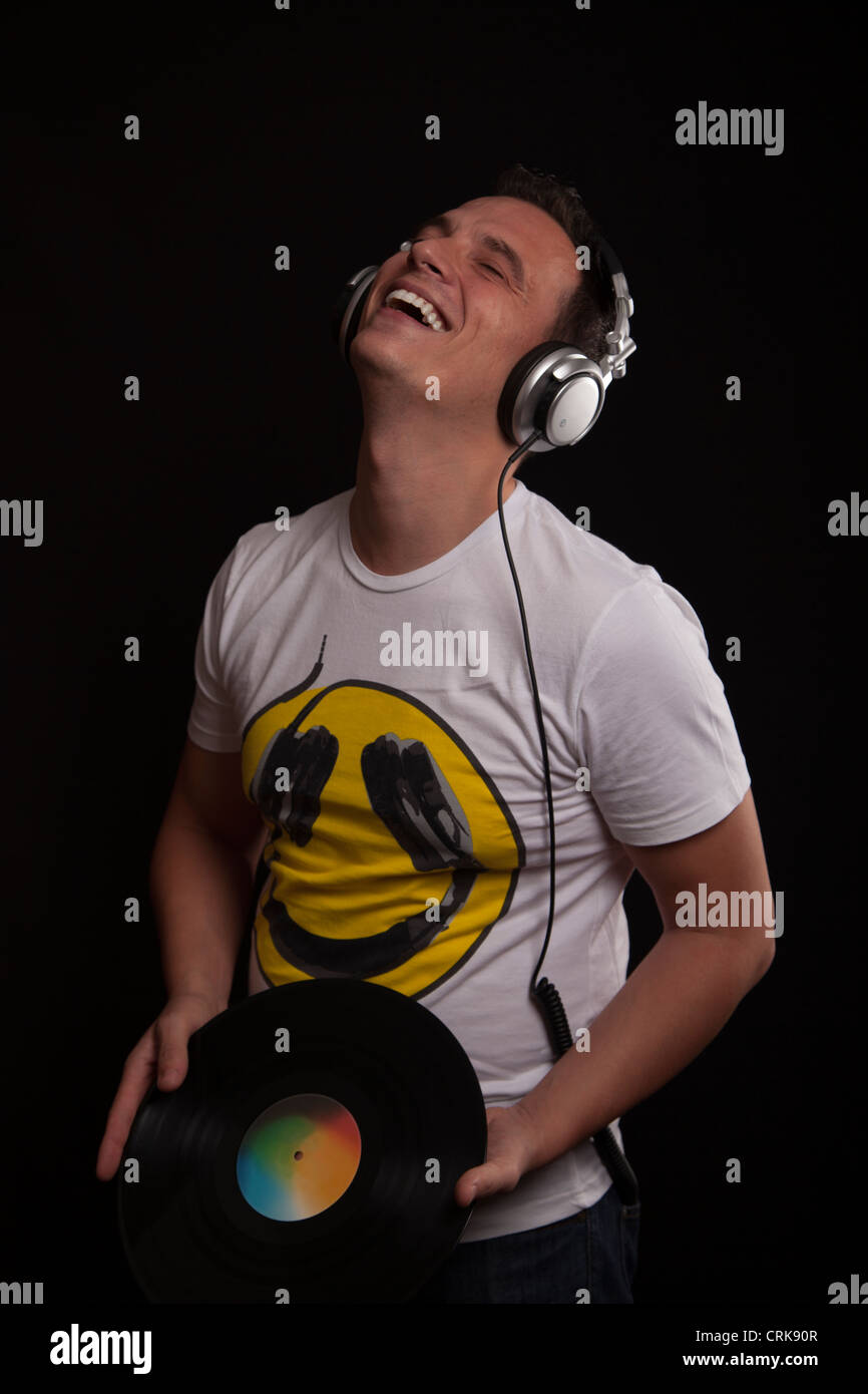 DJ a ridere con un disco in vinile nelle sue mani Foto Stock