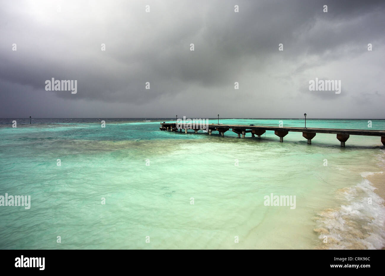 Vista del molo principale al villaggio Embudu alle Maldive con piogge monsoniche voce a. Foto Stock