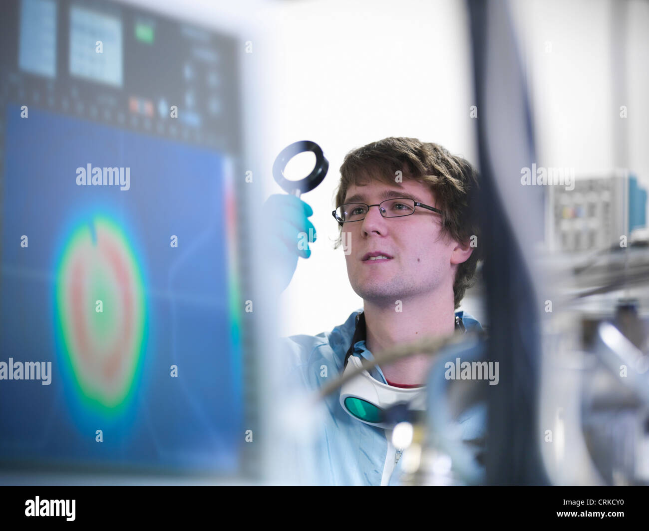 Scienziato esaminando lente in lab Foto Stock