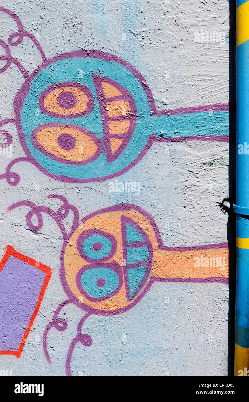 Due giocosi volti sorridenti sono verniciati a spruzzo lateralmente su un graffiti parete riempito nel centro cittadino di Aberdeen, Washington. Foto Stock