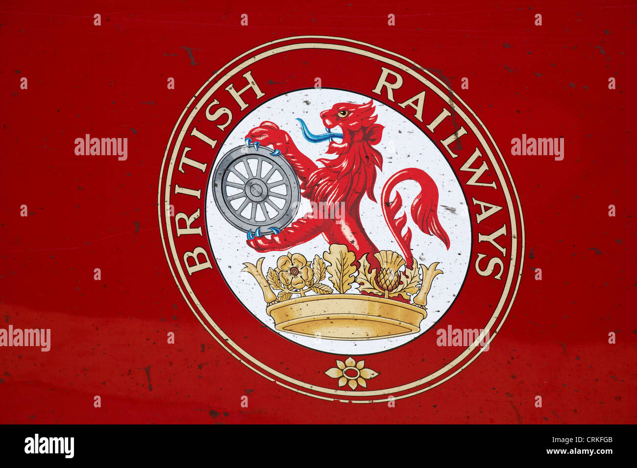 Logo della British Railways sul lato della carrozza rossa macchiato di segni sporchi - primo piano della cresta di leone sulla locomotiva BR Foto Stock