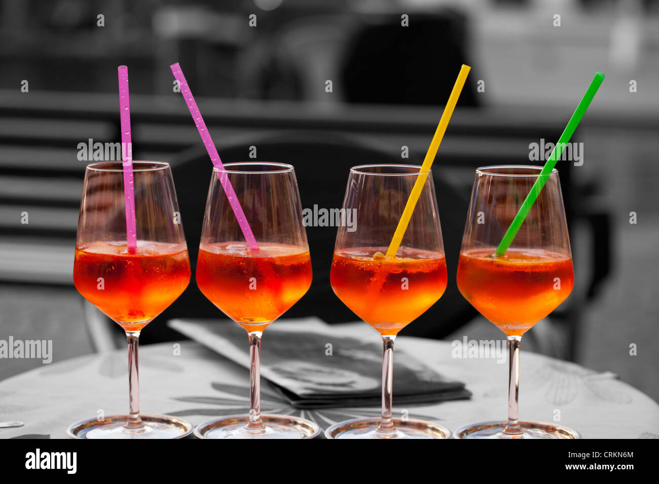 Bicchieri di vino pieno di Spritzer spruzzi di colore su di una tavola di ristorante Foto Stock