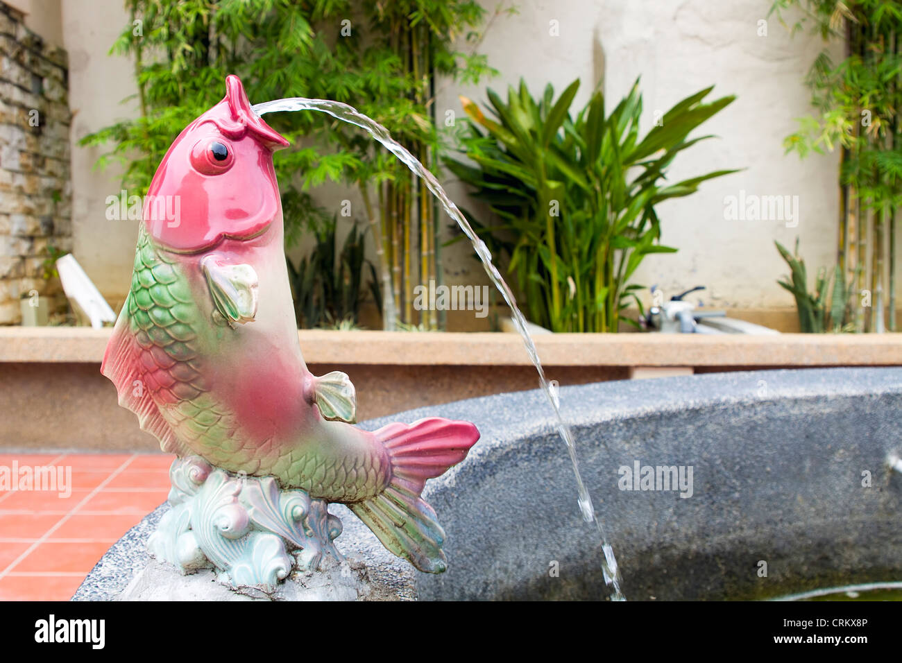 Uno spettacolare pesce Koi statua la germogliazione di acqua sul laghetto di Fontana Foto Stock