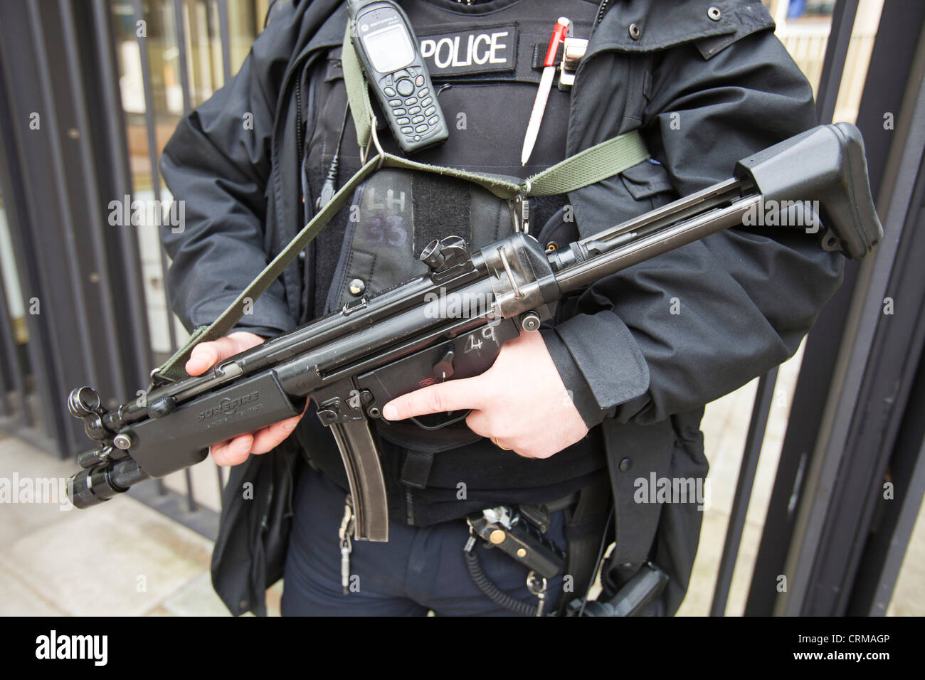 Agente di polizia armato proteggere l'Ambasciata americana in Grosvenor Square, Londra, Regno Unito. Foto Stock
