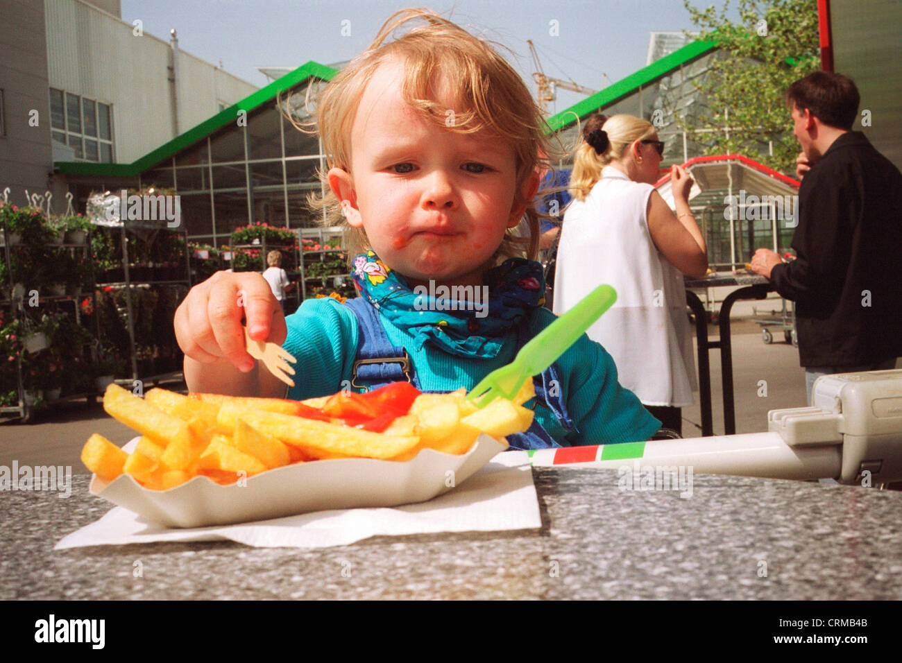 Berlino, un ragazzo di mangiare la sua patate fritte con ketchup Foto Stock