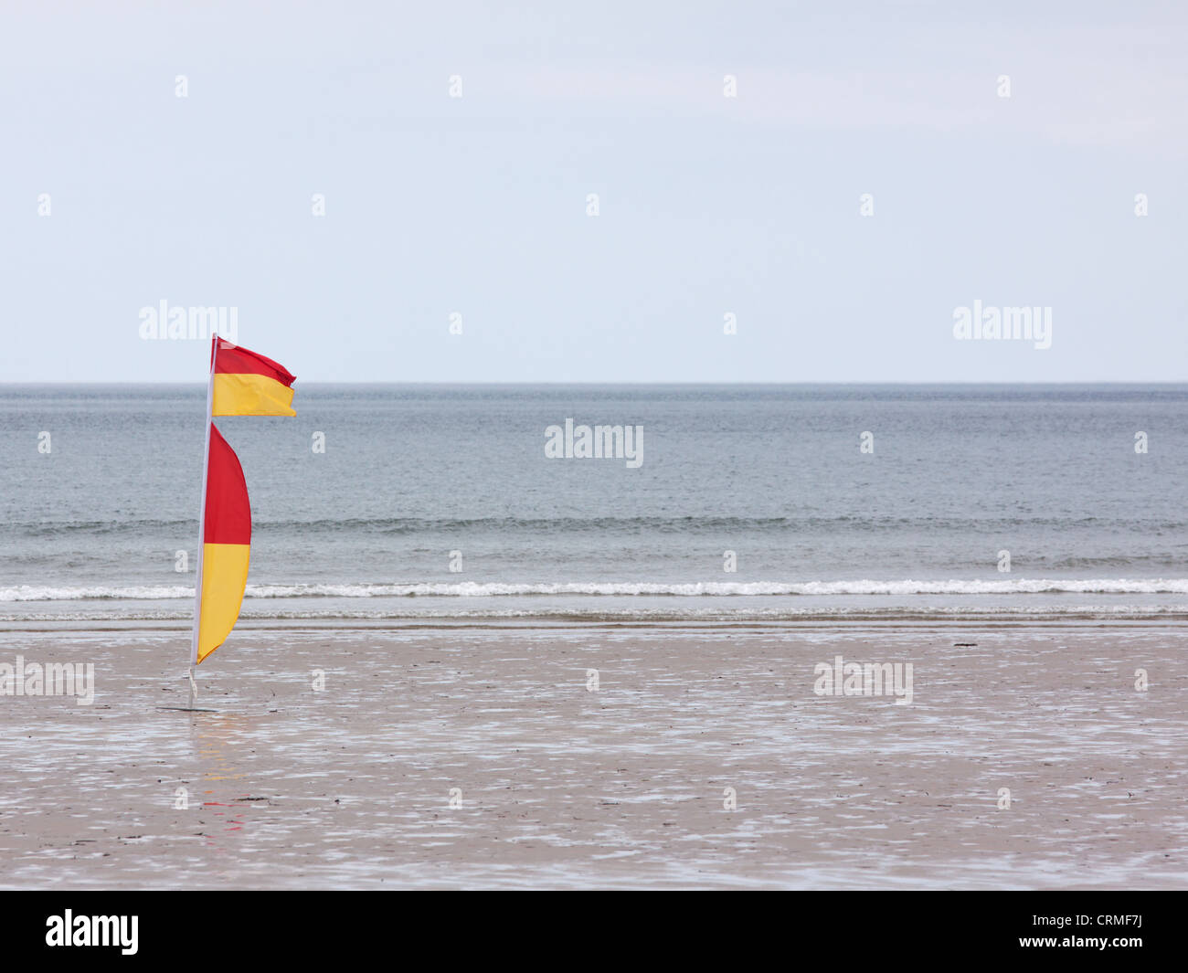 Rosso e giallo di bandiera sulla spiaggia di Westward Ho !, Inghilterra indicando una balneazione sicura e zona di surf sorvegliata da bagnini Foto Stock