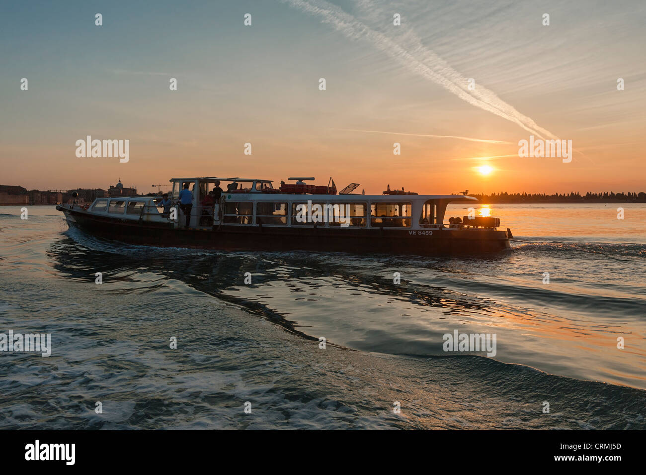 Un valporetto o autobus di acqua che attraversa la laguna di Venezia al tramonto Foto Stock