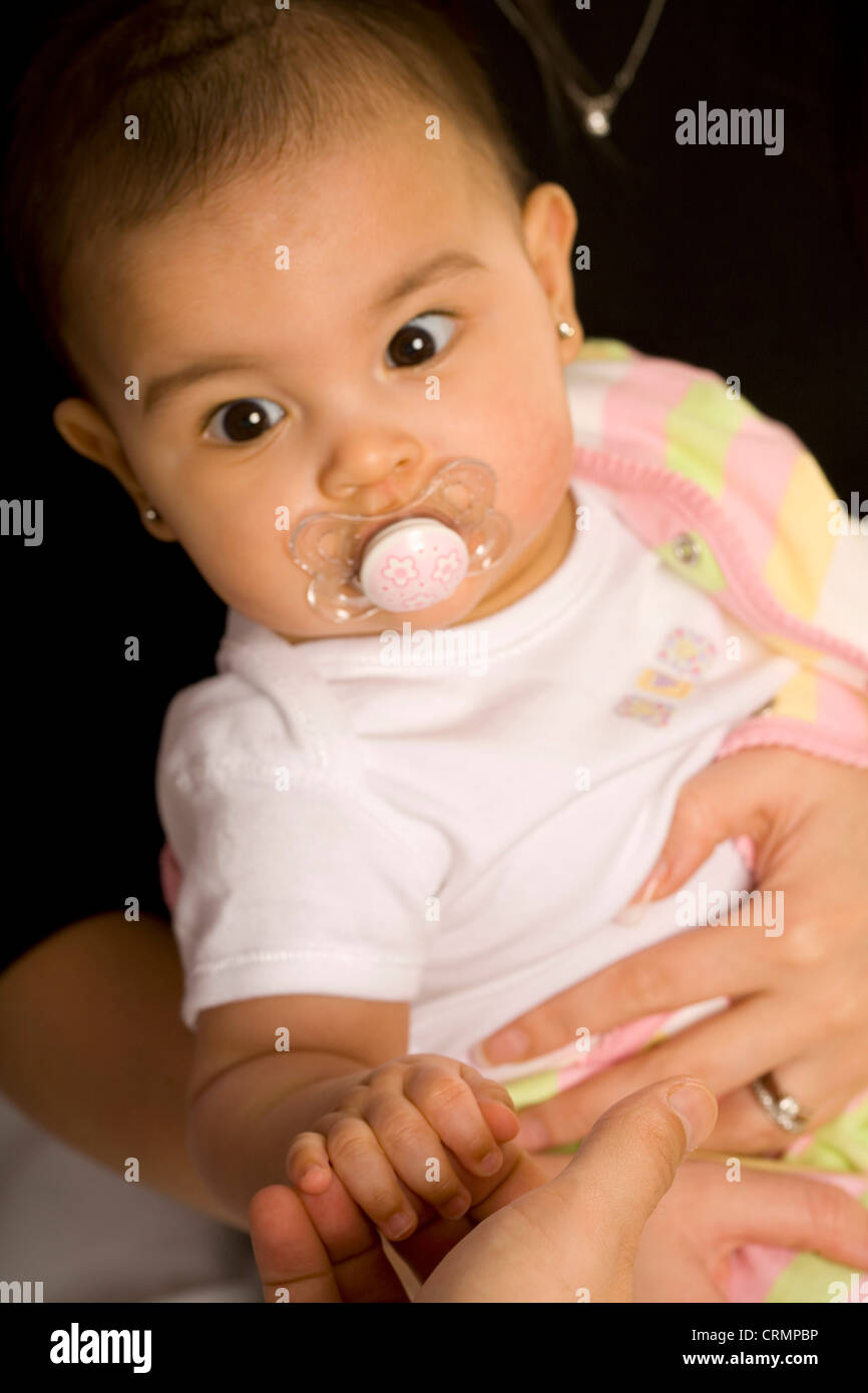 Una bambina con un manichino nella sua bocca. Foto Stock