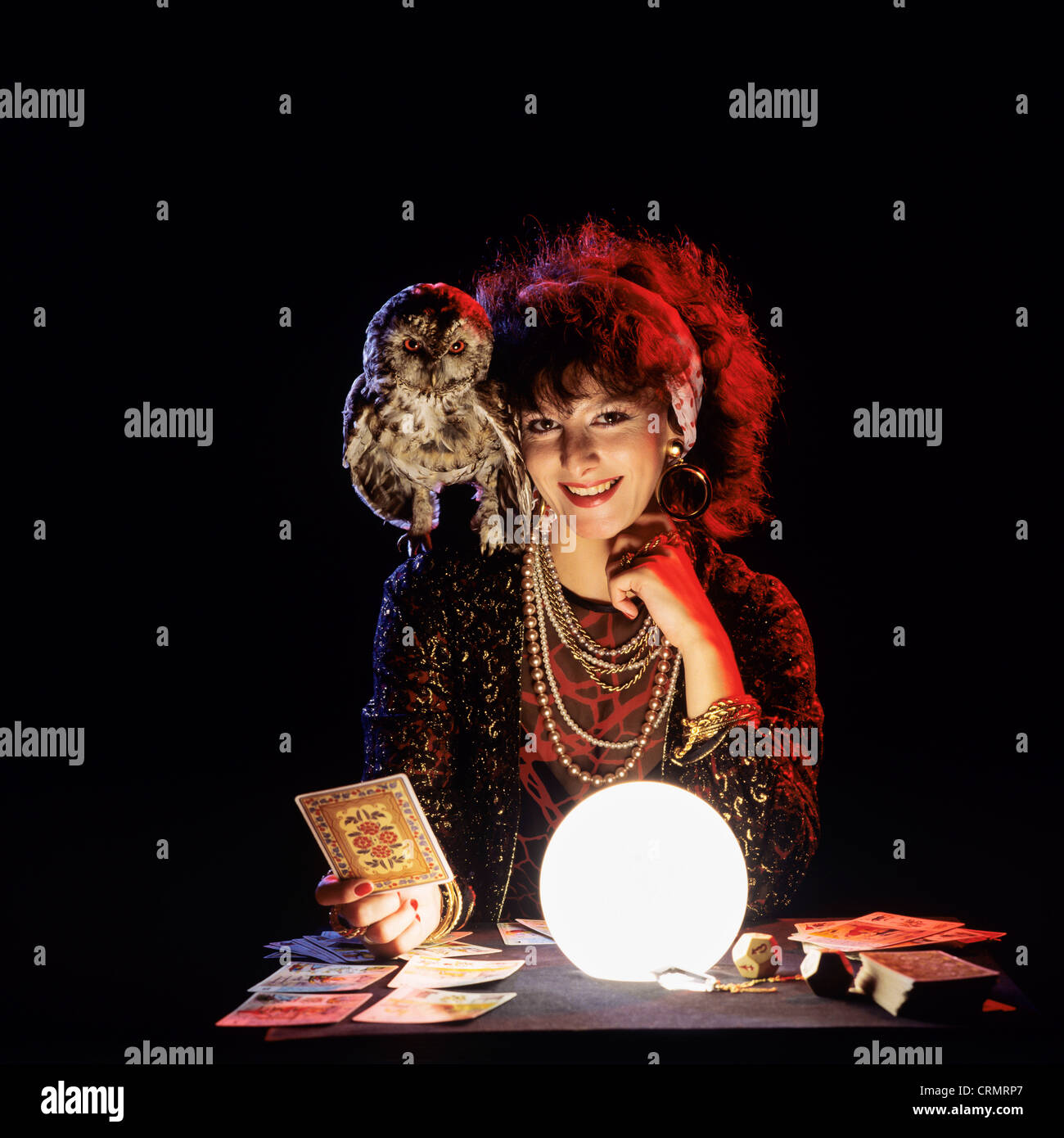 Gipsy fortune teller con un gufo sulla sua spalla, tarocchi e accesa sfera di cristallo Foto Stock