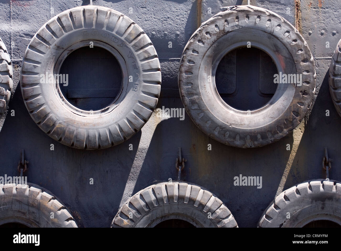Vecchi pneumatici usati come i paraurti di protezione sospesa sull'esterno nello scafo di una chiatta Foto Stock