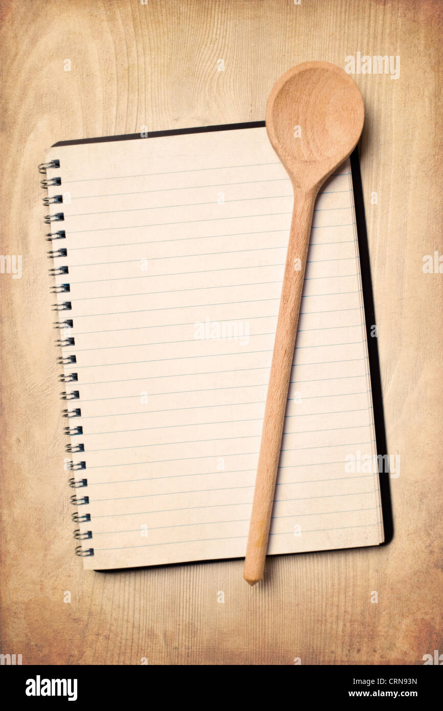 Blank libro di ricette con il cucchiaio di legno Foto Stock