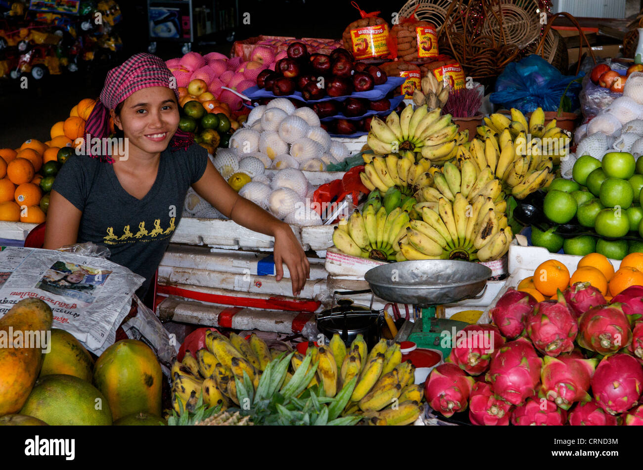 Venditore di frutta che indossa krama (sciarpa tradizionale cambogiana) espositore di frutta all'aperto con banane, frutta e mele drago, Siem Reap, Cambogia. © Kraig Lieb Foto Stock