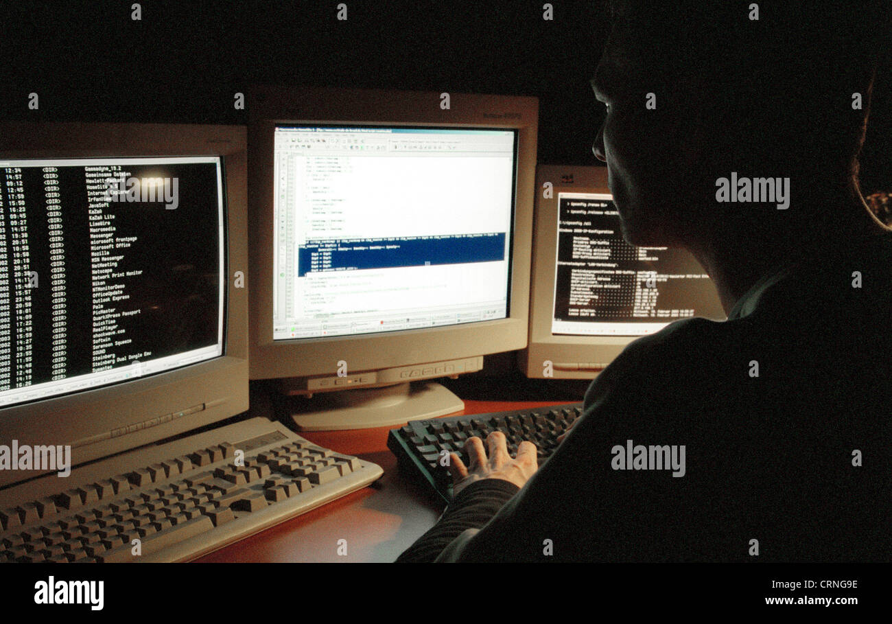 Un giovane uomo seduto nella parte anteriore del monitor per computer Foto Stock