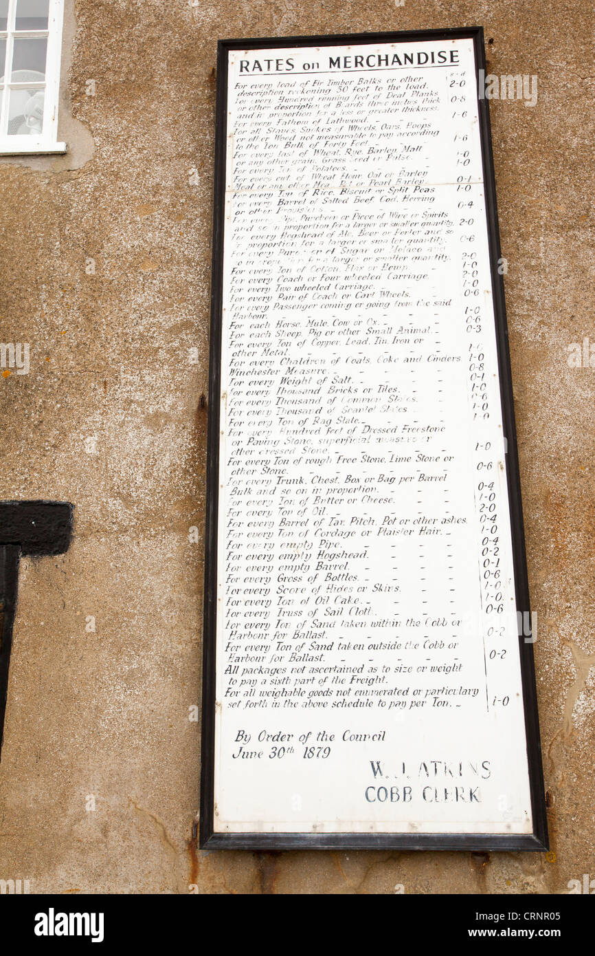 Una vecchia scheda con le aliquote tariffarie sulle merci importate in Lyme Regis Harbour, Dorset, Regno Unito. Foto Stock