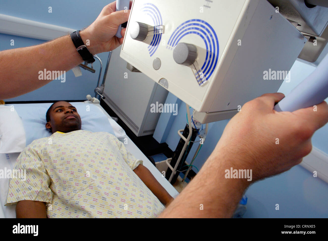 Un radiologo la preparazione di un paziente per examiantion al di sotto di una macchina a raggi x. Foto Stock