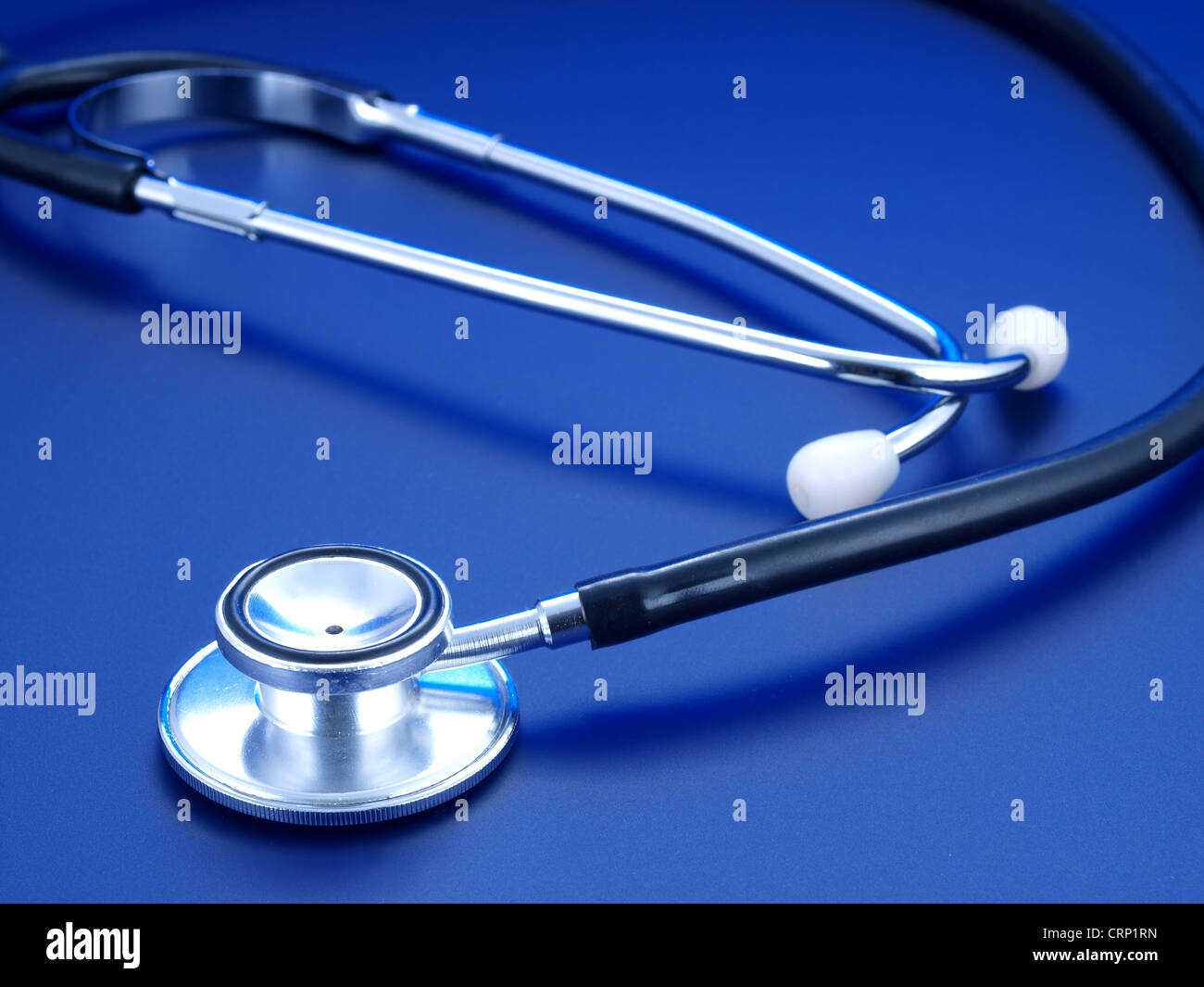 Lo stetoscopio e pillole blu su sfondo blu. Foto Stock