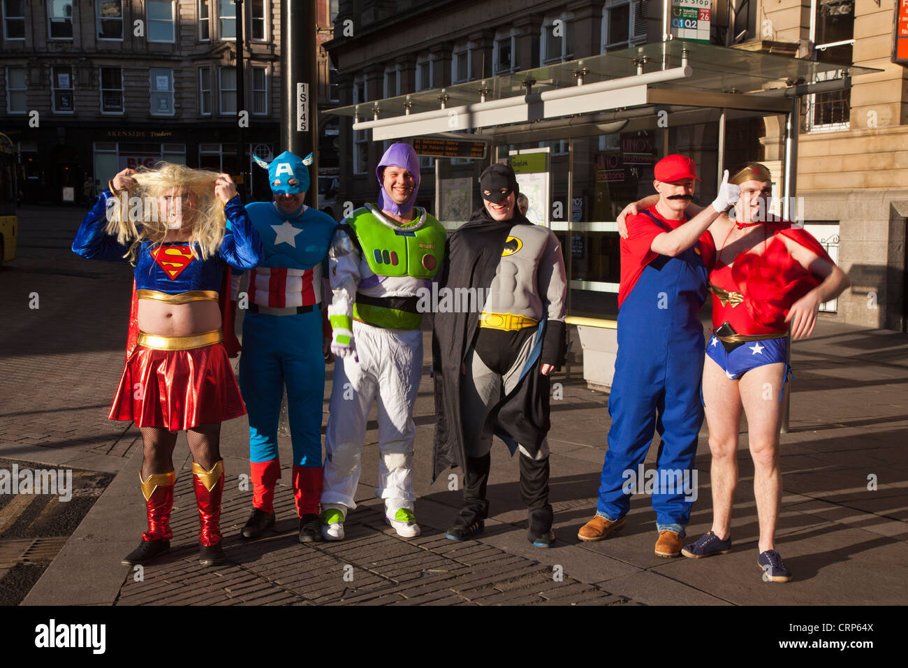 Un gruppo di uomini vestiti come super eroi e personaggi animati su un weekend Stag. Foto Stock