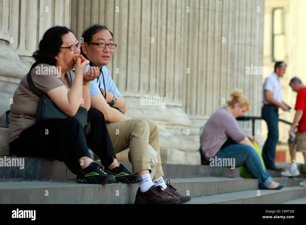 East Asian matura sui gradini della cattedrale di St Paul, Londra Foto Stock