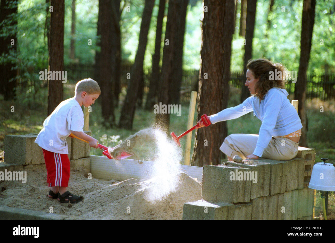 Little Boy giocando con una donna nel sandbox, Brandenburg Foto Stock