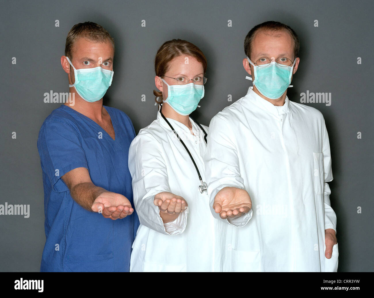 I medici e gli infermieri con maschere chirurgiche chiedono denaro Foto Stock