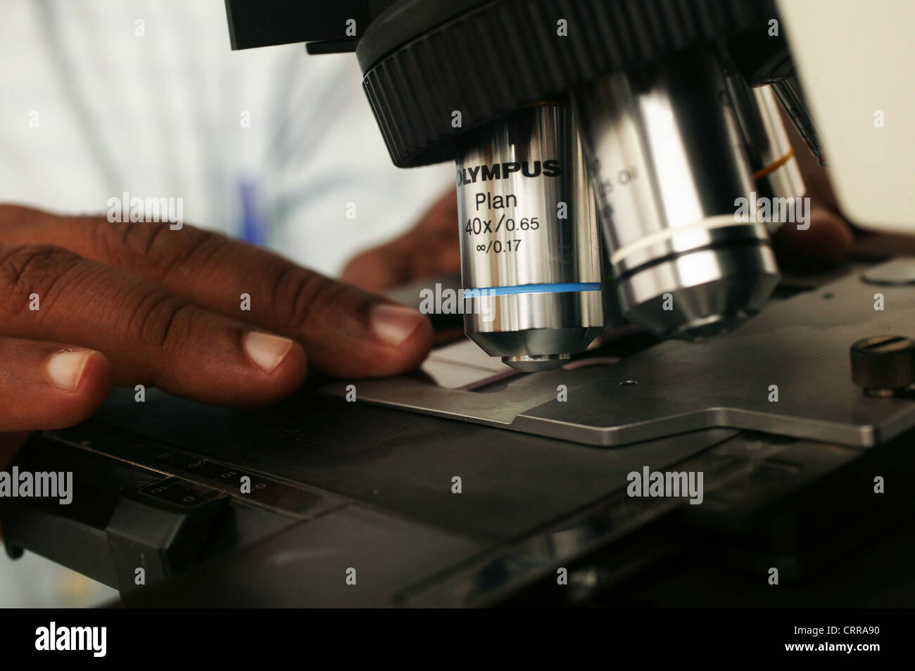Close-up delle lenti di un microscopio mentre è azionato da un patologo. Foto Stock