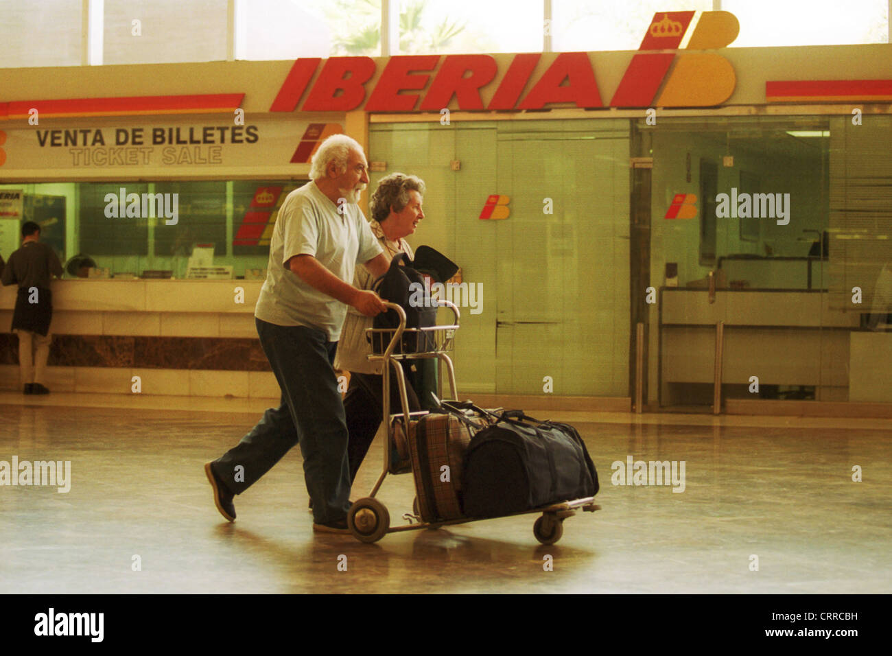 I viaggiatori di fronte a un interruttore della compagnia aerea Iberia Foto Stock