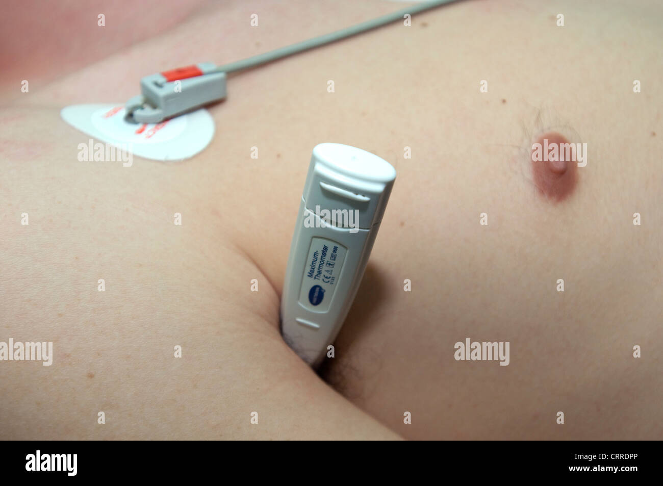 La lettura del termometro la temperatura di un paziente Foto Stock