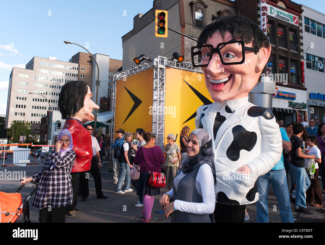 Testa gigante in cartapesta caratteri passeggiando sul Ste-Catherine street durante il giusto per Ride Festival di Montreal, Quebec, Foto Stock