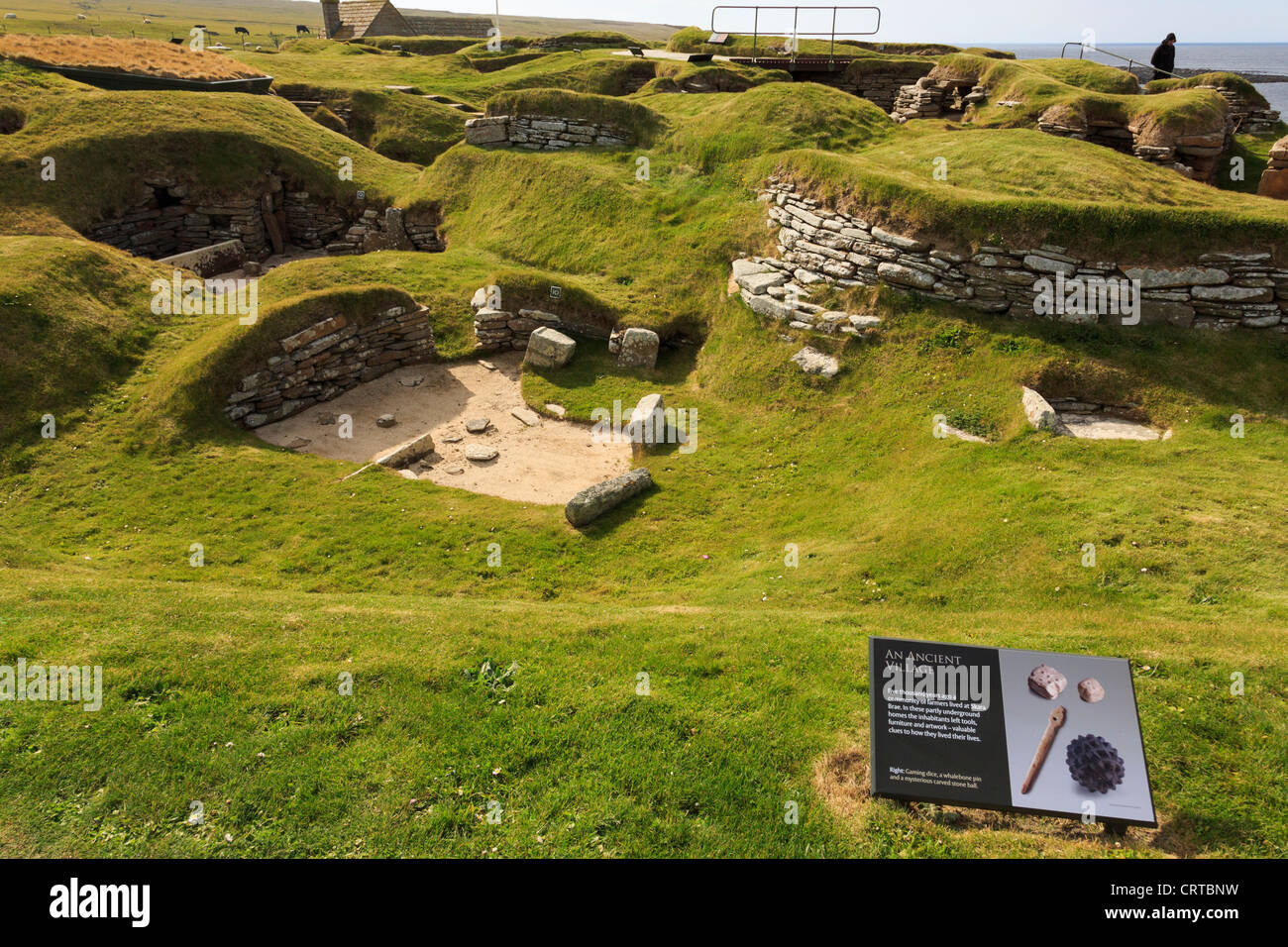 Gli scavi delle antiche abitazioni preistoriche nel villaggio neolitico di Skara Brae con informazioni di segno. Isole Orcadi Scozia UK Foto Stock