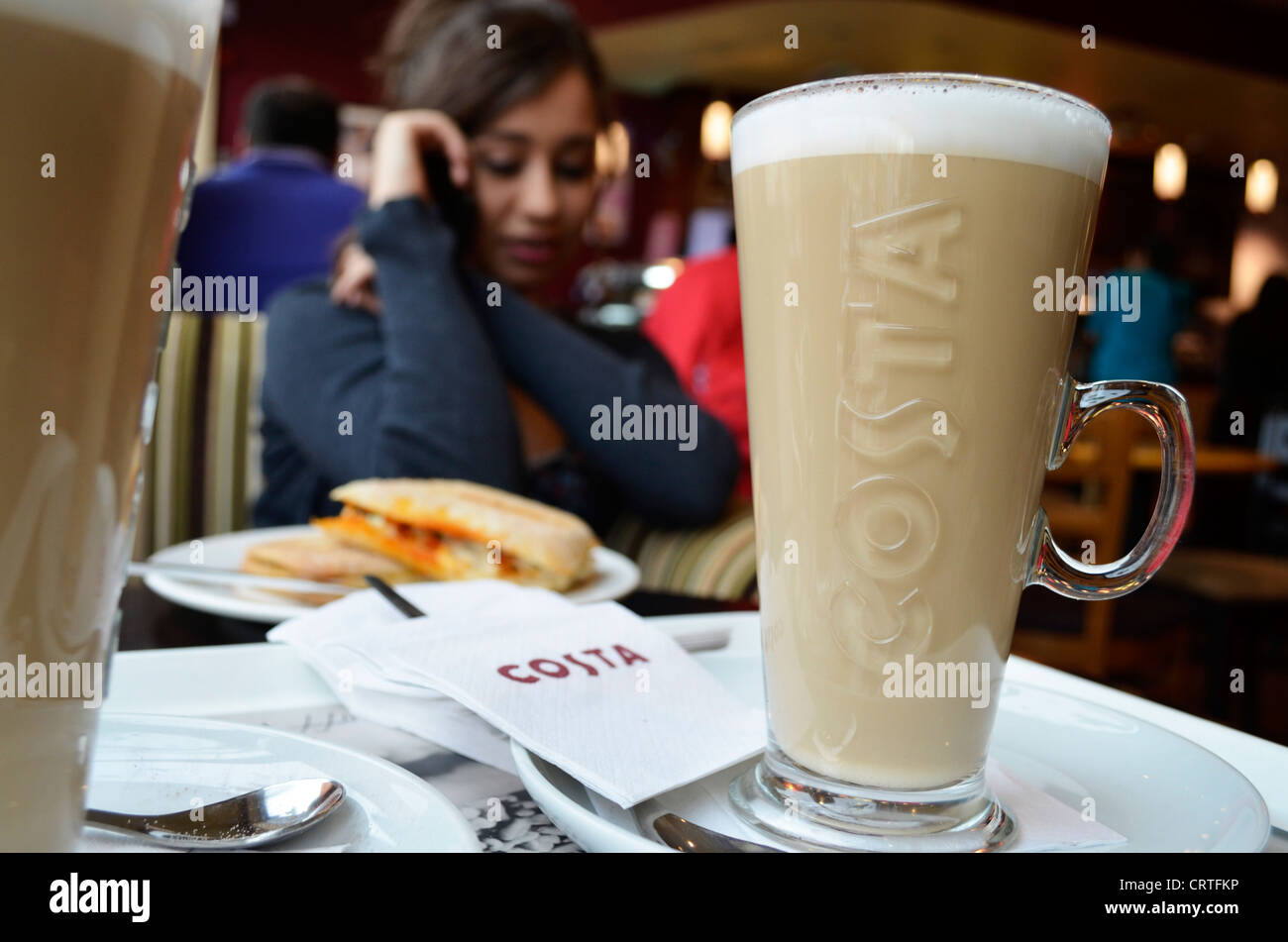 Socializzazione in Costa il caffè con una tazza di latte Foto Stock