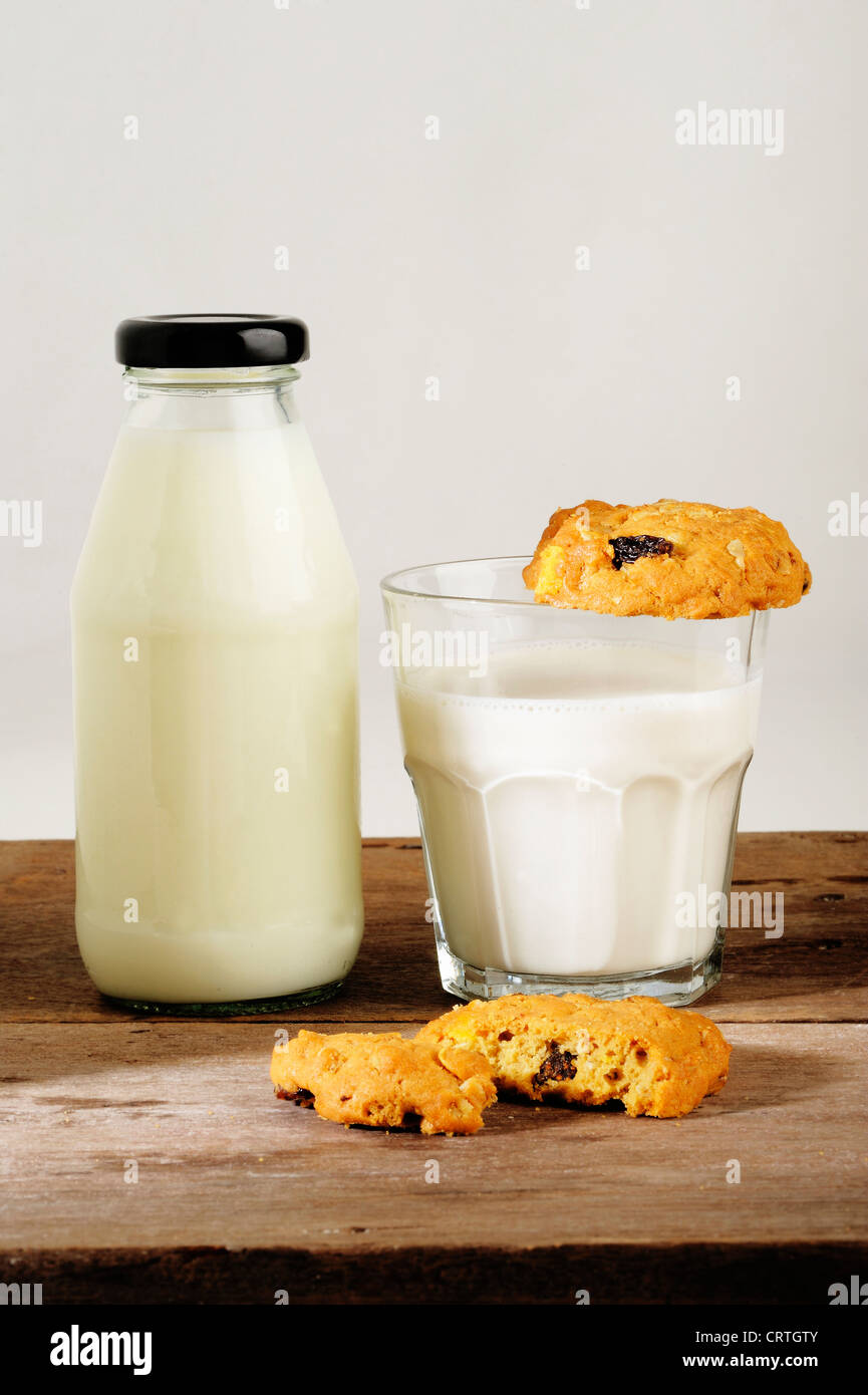 Il latte con i cookie su sfondo di legno Foto Stock