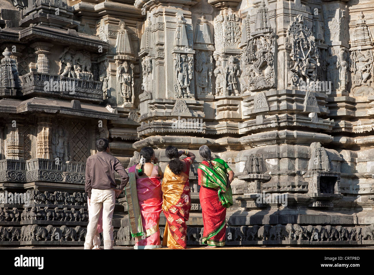 Persone contemplando le sculture. Tempio di Chennakeshava. Belur. India Foto Stock