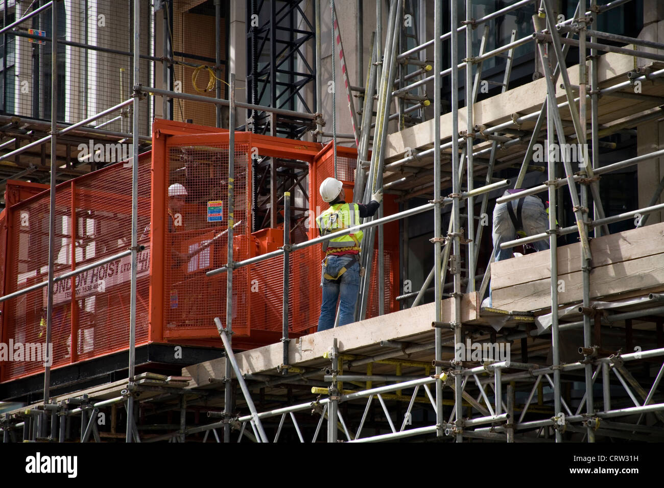 Lavoratori edili sui ponteggi nella City di Londra Foto Stock
