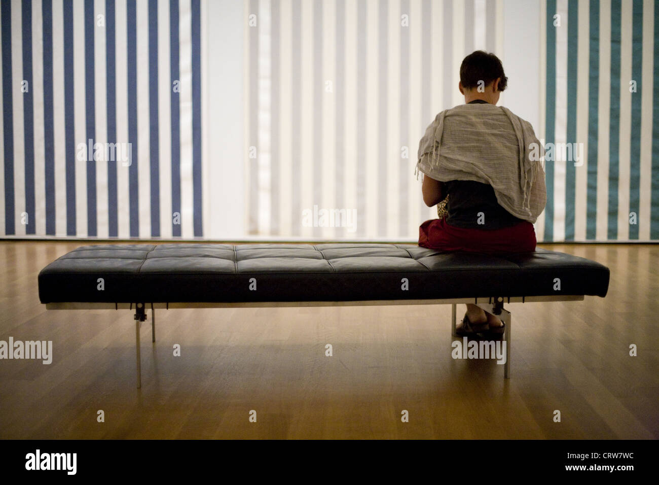 Lone donna seduta sul banco al MOMA di New York Foto Stock