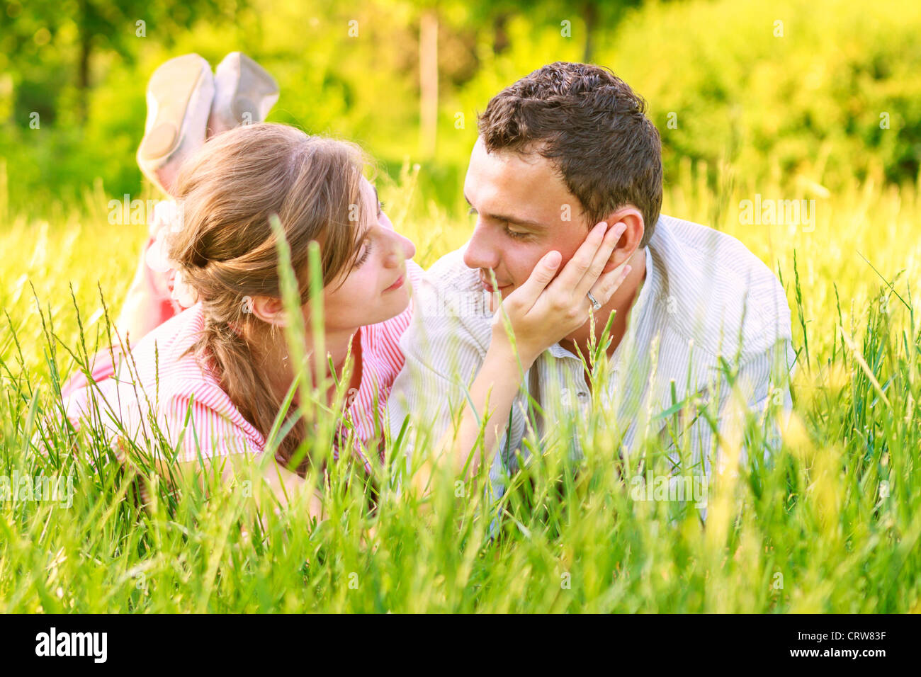 Close-up di una giovane coppia in amore sull'erba Foto Stock