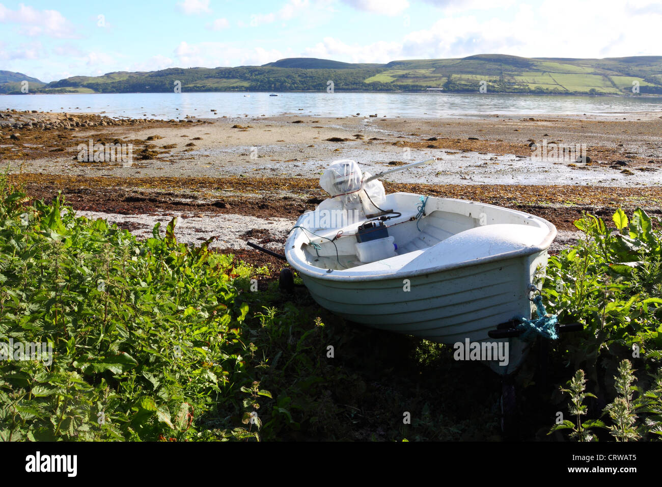 Barca sulla riva del Kyles of Bute, Argyll, Scozia, con l'isola di Bute a distanza Foto Stock