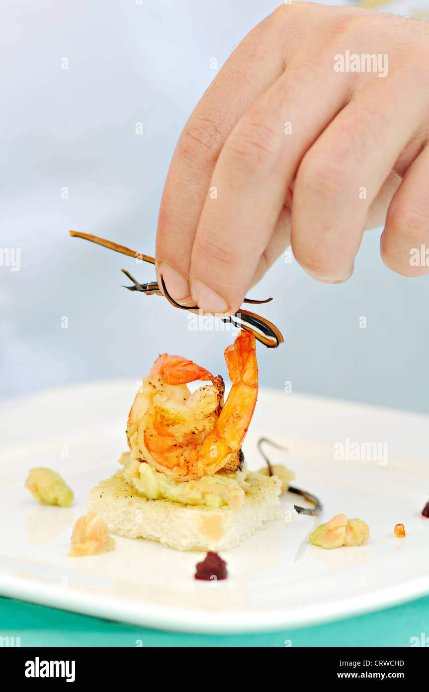 Mano umana impostazione di un tostato delizioso pasto adibiti alla pesca di gamberetti Foto Stock