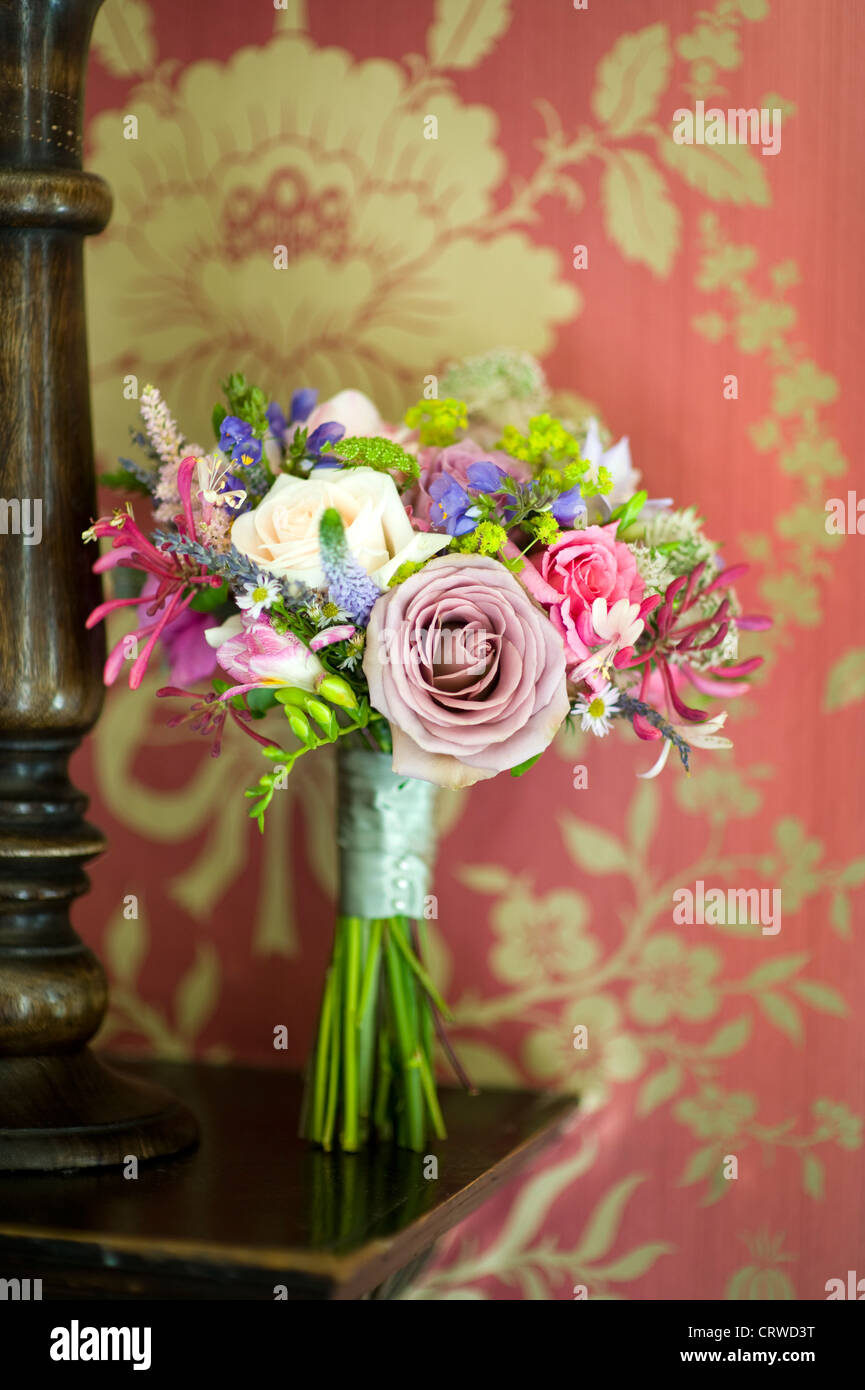 Bouquet di nozze su un ripiano di legno con vintage carta da parati Foto Stock