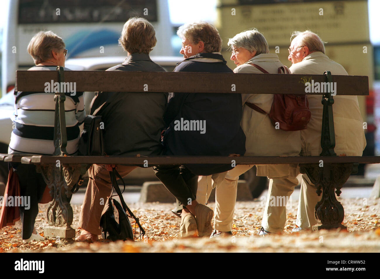 I pensionati seduti su una panchina e parlando Foto Stock