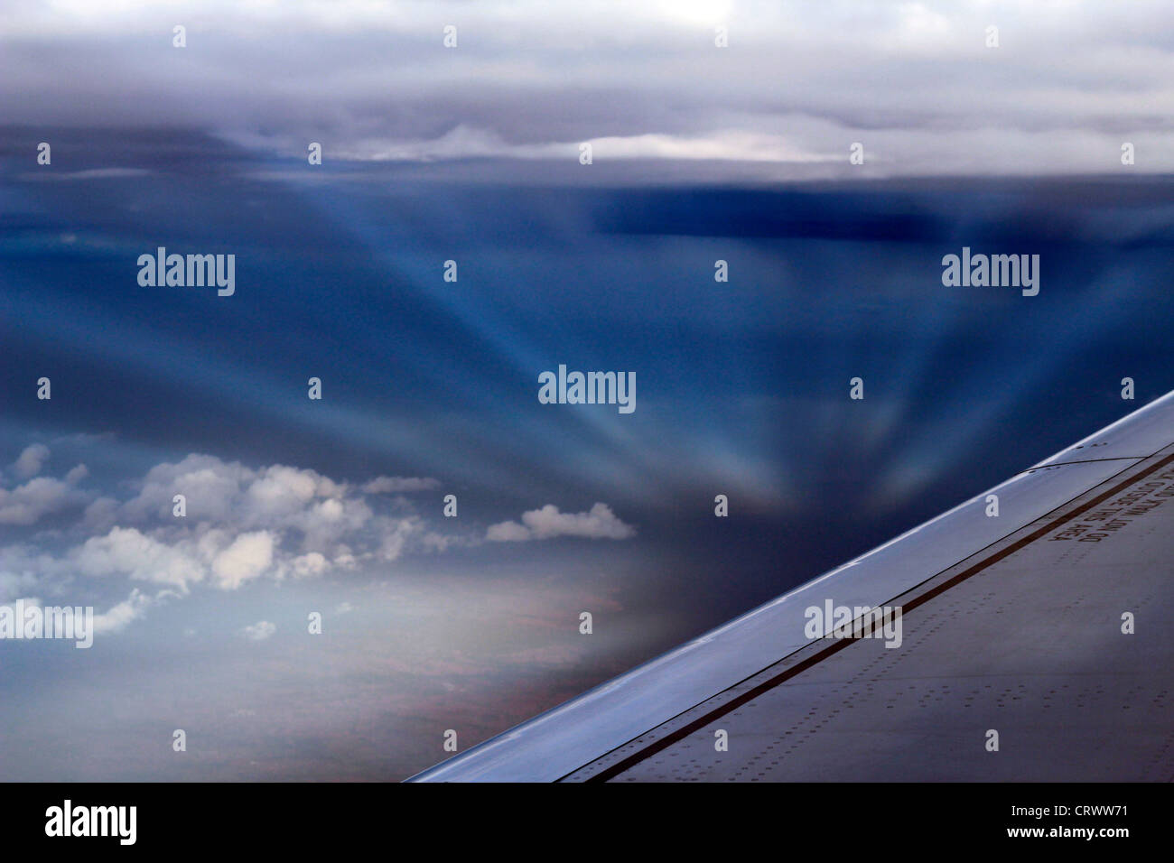 Raggi del sole formando una vista mozzafiato tra le nuvole come visto da un aereo finestra. Foto Stock