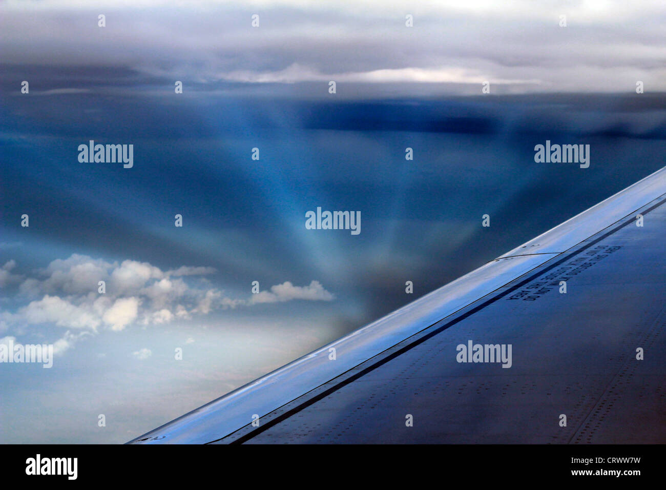 Raggi del sole formando una vista mozzafiato tra le nuvole come visto da un aereo finestra. Foto Stock