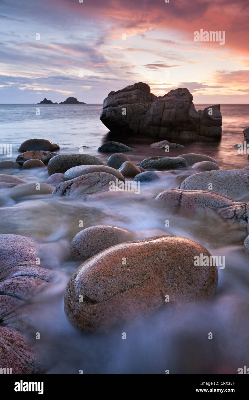 Porth Nanven cove e le isole Brisons al tramonto, Cornwall, Inghilterra. Molla (aprile 2012). Foto Stock