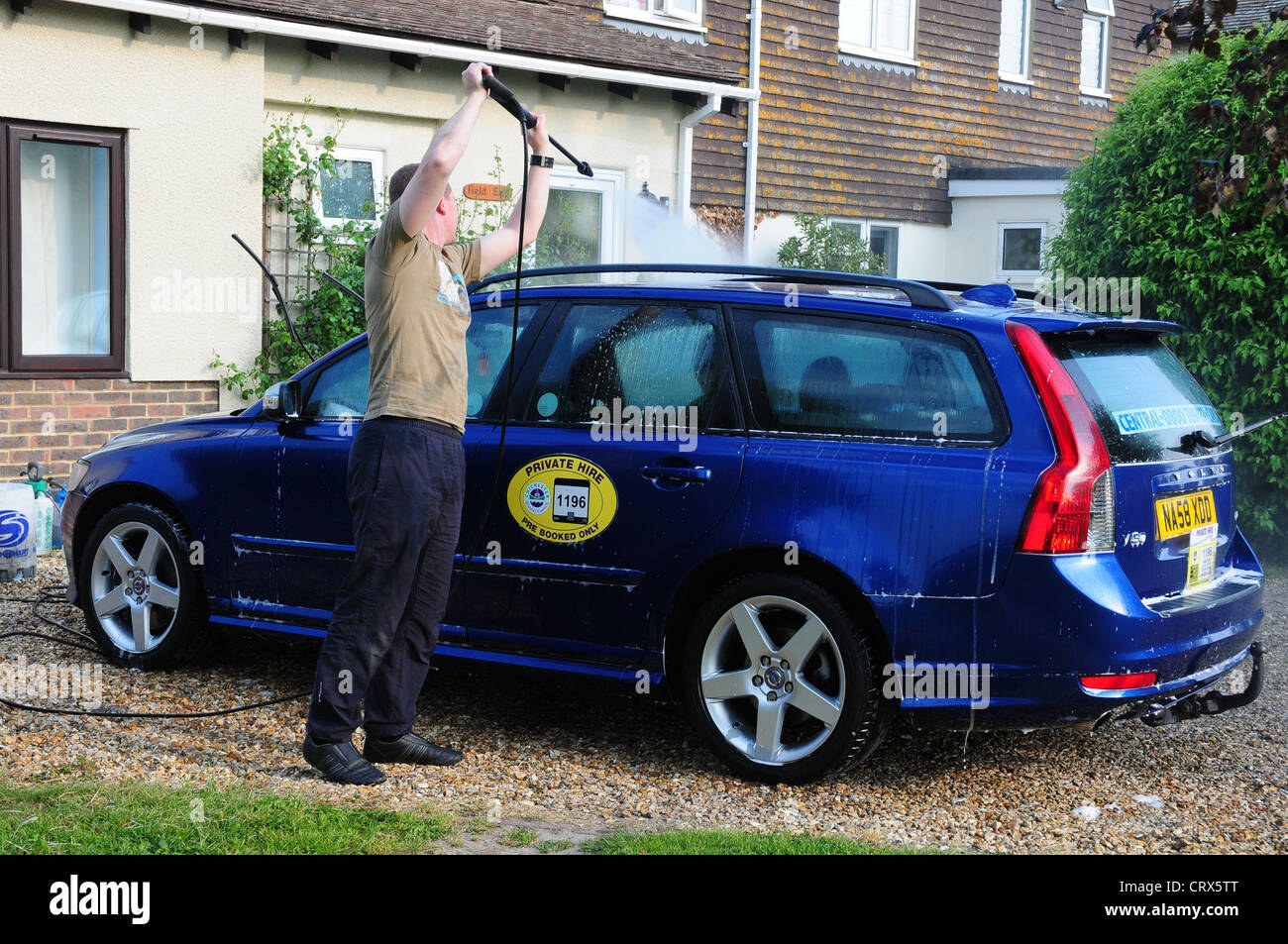 Giovane uomo valeting un noleggio privato auto. Foto Stock