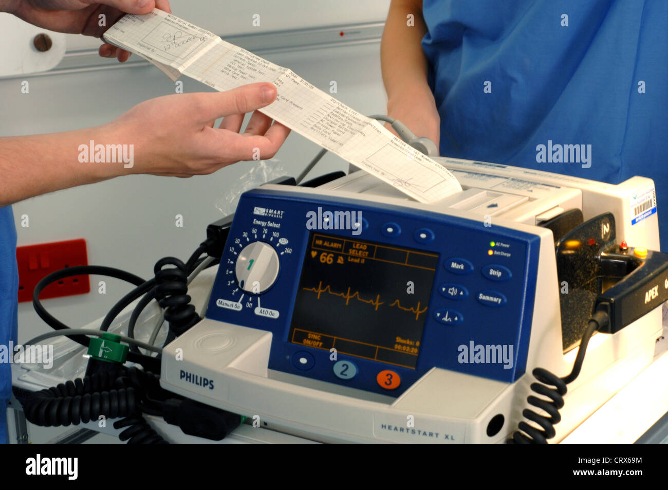 I medici controllare la lettura data dopo utilizzando un defibrillatore, di resuscitare un attacco di cuore vittima. Foto Stock