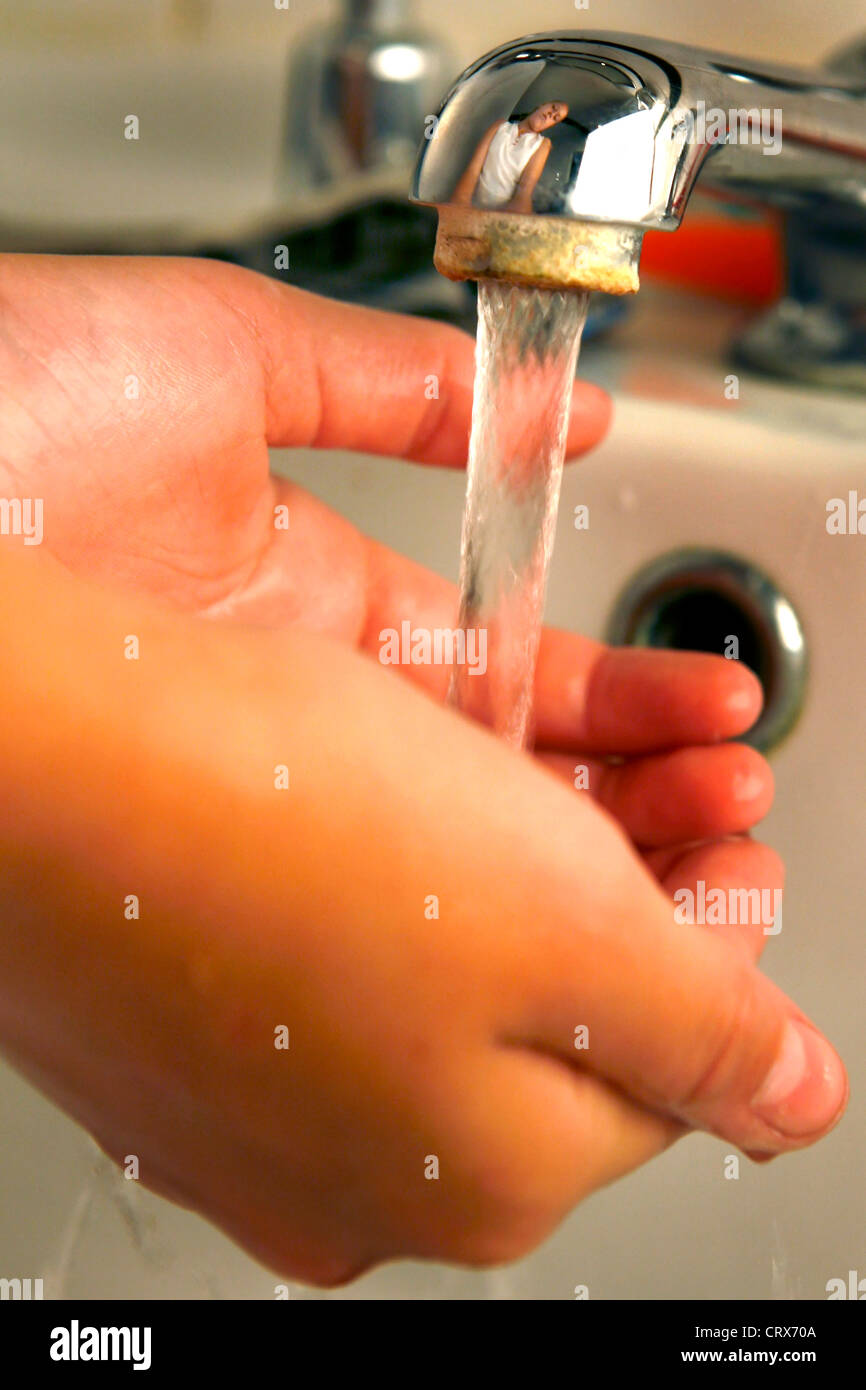 Una giovane ragazza lavando le mani nel lavandino sotto il rubinetto. Foto Stock