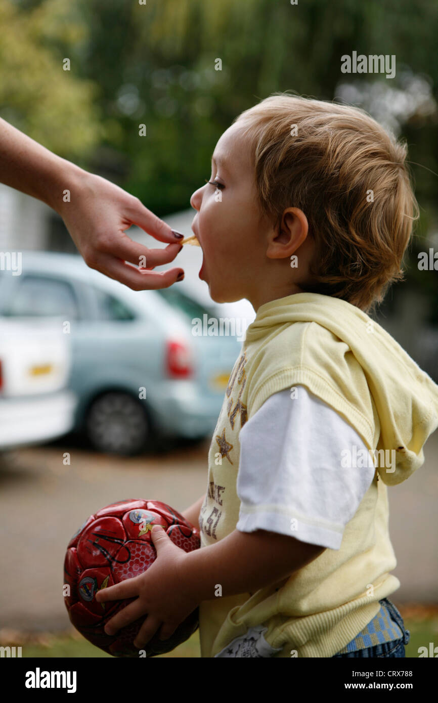 Un bambino a rosicchiare una malsana patatine. Foto Stock