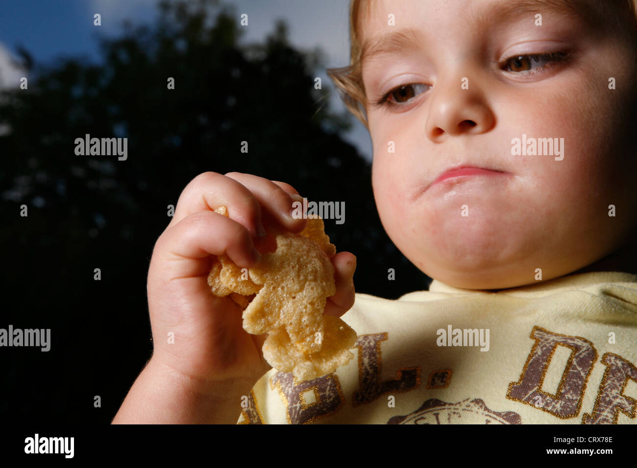 Un bambino con una manciata di malsano le patatine. Foto Stock